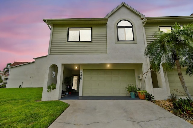 549 Walden Ct, Dunedin, FL 34698 - view of property with stucco siding, a front lawn, a garage, and concrete driveway