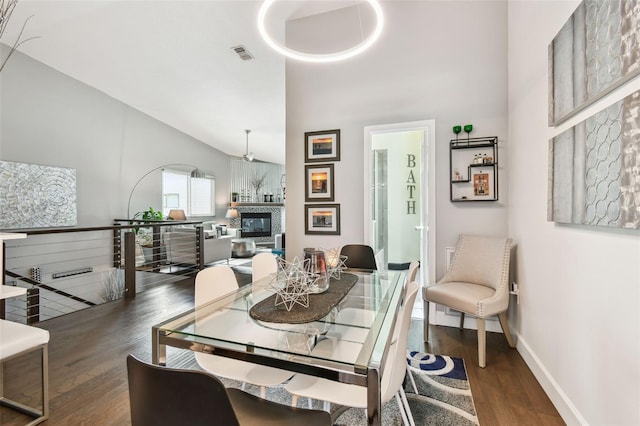549 Walden Ct, Dunedin, FL 34698 - dining area featuring wood finished floors, high vaulted ceiling, and a glass covered fireplace