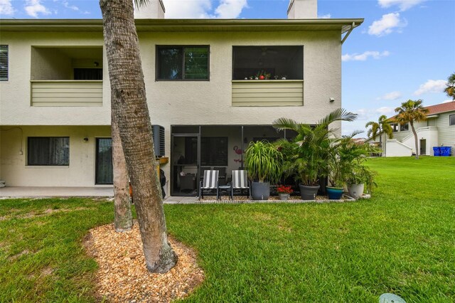 549 Walden Ct, Dunedin, FL 34698 - back of property with stucco siding, a lawn, a chimney, and a patio