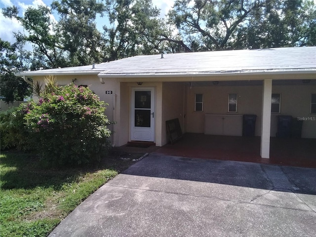 390 301st Blvd W Unit 8D, Bradenton, FL 34205 - view of front facade featuring a carport, driveway, and stucco siding