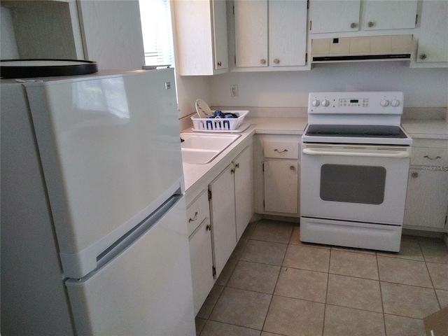 390 301st Blvd W Unit 8D, Bradenton, FL 34205 - kitchen with white appliances, exhaust hood, light countertops, light tile patterned floors, and white cabinetry