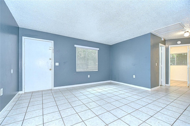 37740 Waverly Ave, Zephyrhills, FL 33542 - empty room with a textured ceiling, plenty of natural light, and light tile patterned flooring