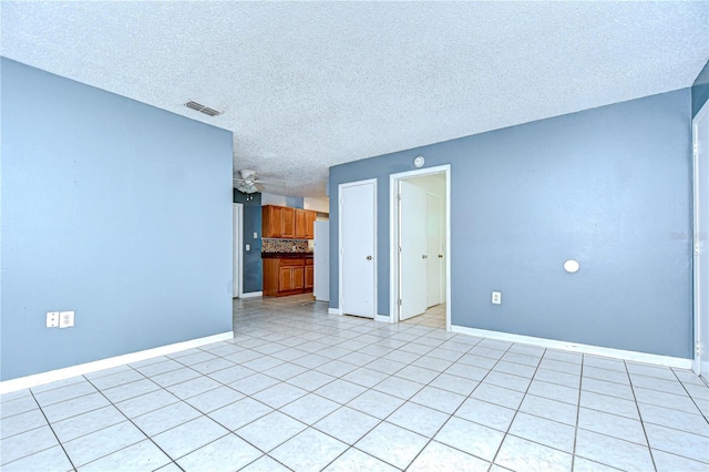 37740 Waverly Ave, Zephyrhills, FL 33542 - empty room featuring a textured ceiling, a ceiling fan, and light tile patterned floors