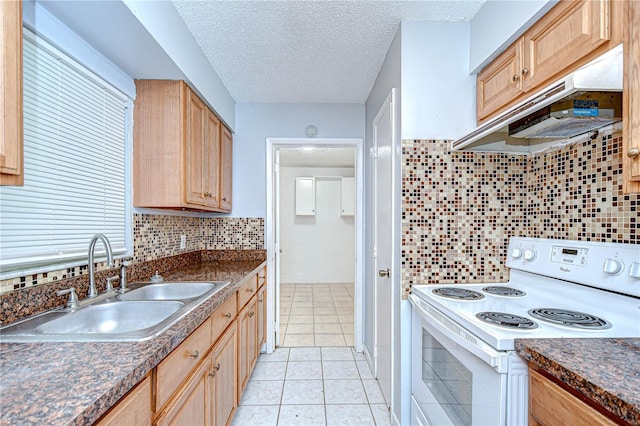 37740 Waverly Ave, Zephyrhills, FL 33542 - kitchen with white electric range, under cabinet range hood, light brown cabinets, dark countertops, and light tile patterned floors