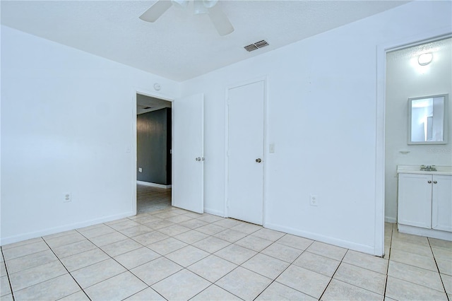 37740 Waverly Ave, Zephyrhills, FL 33542 - unfurnished bedroom with light tile patterned floors, ceiling fan, and a closet