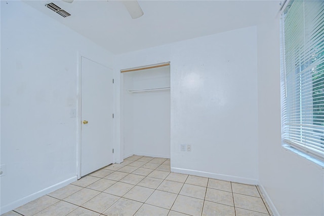 37740 Waverly Ave, Zephyrhills, FL 33542 - unfurnished bedroom featuring light tile patterned floors, ceiling fan, and a closet