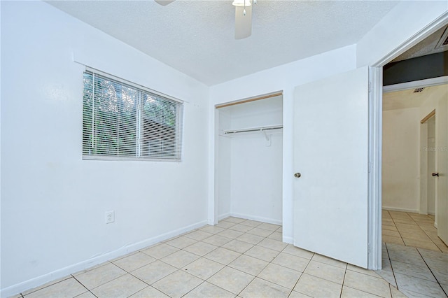 37740 Waverly Ave, Zephyrhills, FL 33542 - unfurnished bedroom with a closet, light tile patterned floors, a textured ceiling, and ceiling fan