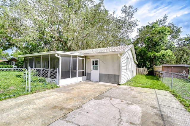 37740 Waverly Ave, Zephyrhills, FL 33542 - view of front of property with a sunroom, driveway, a patio, and a metal roof