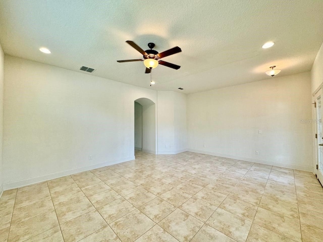 19502 Sea Myrtle Way, Tampa, FL 33647 - spare room with arched walkways, a ceiling fan, a textured ceiling, recessed lighting, and light tile patterned floors