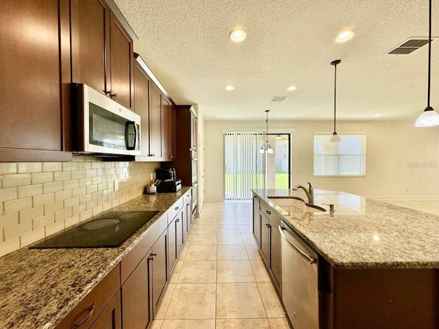 19502 Sea Myrtle Way, Tampa, FL 33647 - kitchen with stainless steel appliances, decorative backsplash, dark stone countertops, an island with sink, and recessed lighting