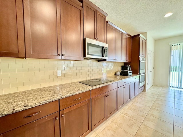 19502 Sea Myrtle Way, Tampa, FL 33647 - kitchen featuring stainless steel appliances, decorative backsplash, light stone counters, light tile patterned flooring, and a textured ceiling