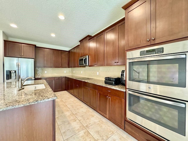 19502 Sea Myrtle Way, Tampa, FL 33647 - kitchen with appliances with stainless steel finishes, a textured ceiling, decorative backsplash, light stone countertops, and light tile patterned floors