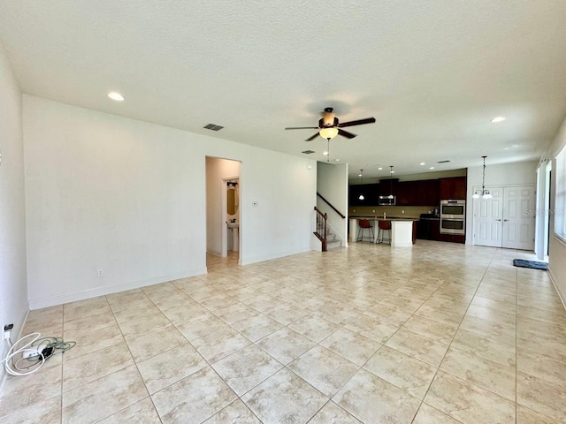 19502 Sea Myrtle Way, Tampa, FL 33647 - unfurnished living room with stairway, ceiling fan, recessed lighting, light tile patterned floors, and a textured ceiling