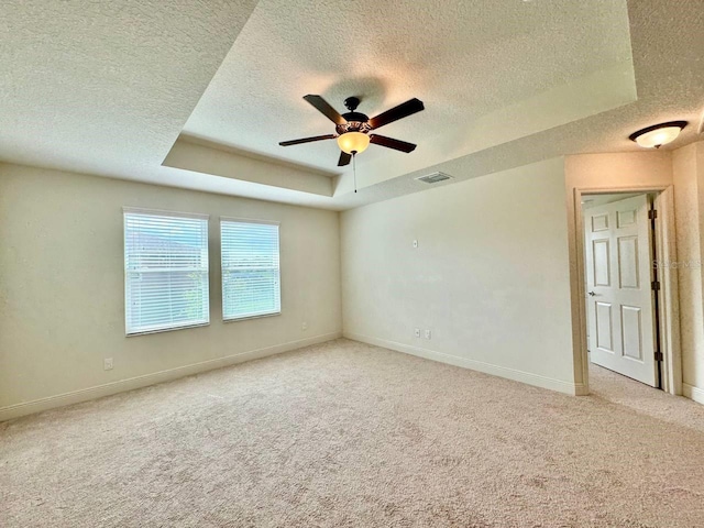 19502 Sea Myrtle Way, Tampa, FL 33647 - empty room featuring a textured ceiling, a tray ceiling, light colored carpet, and ceiling fan