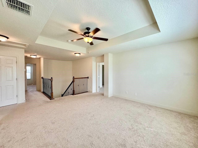 19502 Sea Myrtle Way, Tampa, FL 33647 - spare room featuring a textured ceiling, a raised ceiling, light colored carpet, and ceiling fan