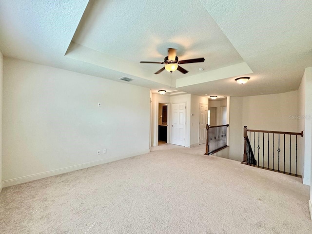 19502 Sea Myrtle Way, Tampa, FL 33647 - spare room with a textured ceiling, a raised ceiling, light carpet, and a ceiling fan
