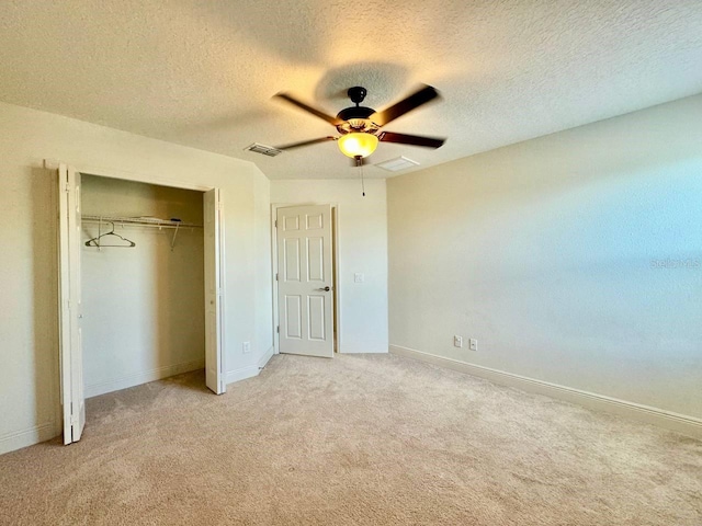 19502 Sea Myrtle Way, Tampa, FL 33647 - unfurnished bedroom featuring light colored carpet, a closet, a textured ceiling, and ceiling fan