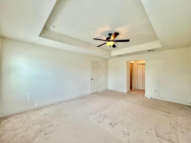 19502 Sea Myrtle Way, Tampa, FL 33647 - spare room with a tray ceiling, a textured ceiling, a ceiling fan, and light carpet