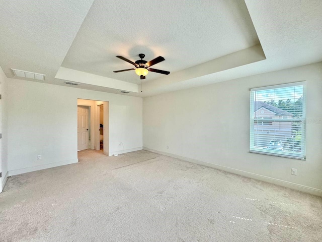 19502 Sea Myrtle Way, Tampa, FL 33647 - unfurnished bedroom with a raised ceiling, a textured ceiling, light carpet, and a ceiling fan