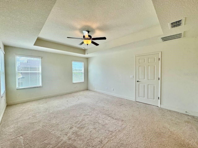 19502 Sea Myrtle Way, Tampa, FL 33647 - unfurnished room featuring a tray ceiling, a textured ceiling, carpet flooring, and a ceiling fan