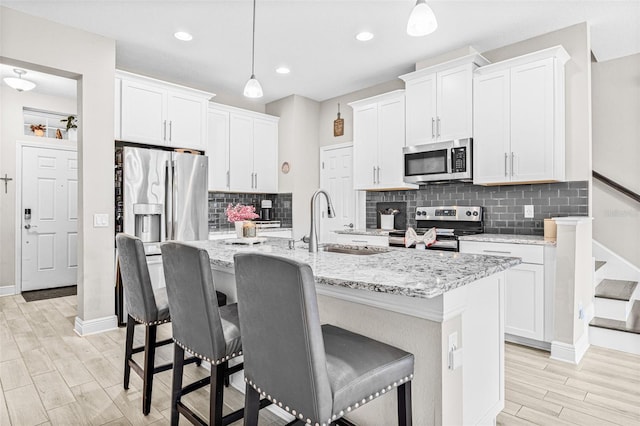9237 Fox Sparrow Rd, Tampa, FL 33626 - kitchen with stainless steel appliances, a kitchen breakfast bar, tasteful backsplash, an island with sink, and recessed lighting