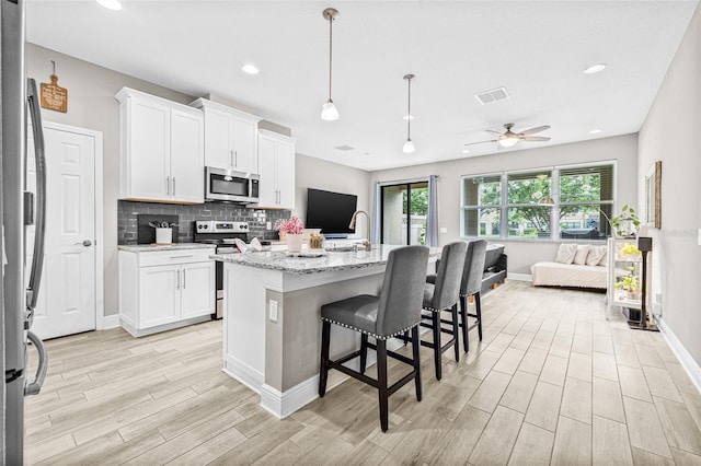 9237 Fox Sparrow Rd, Tampa, FL 33626 - kitchen with appliances with stainless steel finishes, open floor plan, light wood-type flooring, ceiling fan, and recessed lighting