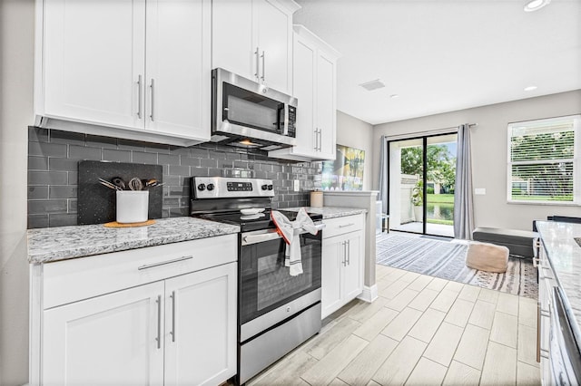9237 Fox Sparrow Rd, Tampa, FL 33626 - kitchen featuring stainless steel appliances, backsplash, white cabinets, light stone countertops, and recessed lighting