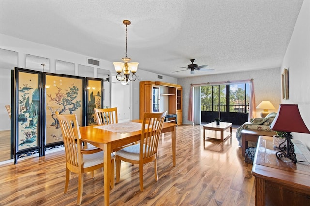 5920 80th St N Unit 308, Saint Petersburg, FL 33709 - dining room with a textured ceiling, wood finished floors, ceiling fan, and a chandelier