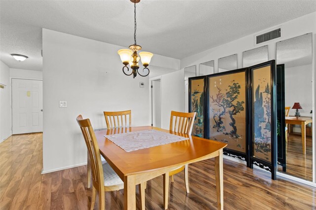 5920 80th St N Unit 308, Saint Petersburg, FL 33709 - dining space featuring a textured ceiling, wood finished floors, and a chandelier