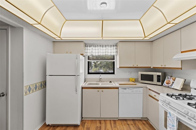 5920 80th St N Unit 308, Saint Petersburg, FL 33709 - kitchen with white appliances, light countertops, light wood finished floors, under cabinet range hood, and cream cabinetry