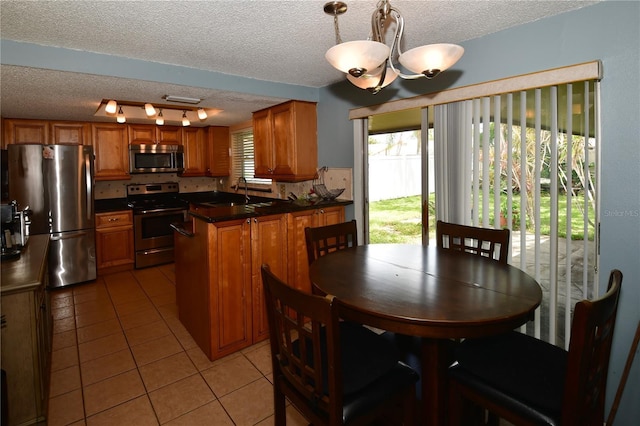 11990 104th Ave, Largo, FL 33778 - dining space with rail lighting, a textured ceiling, light tile patterned flooring, and a chandelier