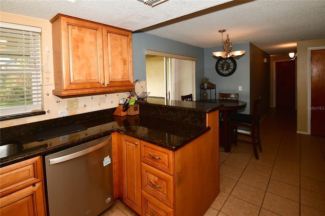 11990 104th Ave, Largo, FL 33778 - kitchen with stainless steel dishwasher, a peninsula, light tile patterned flooring, brown cabinetry, and a textured ceiling
