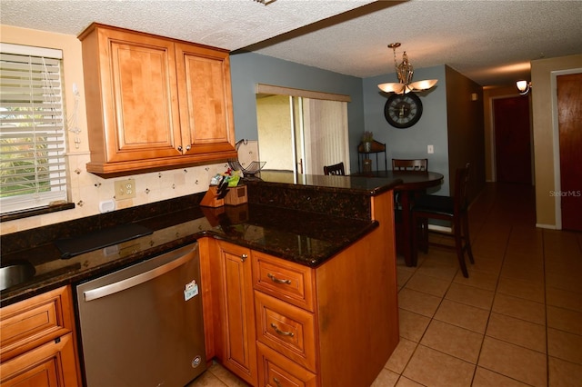 11990 104th Ave, Largo, FL 33778 - kitchen with stainless steel dishwasher, a peninsula, light tile patterned floors, brown cabinets, and a textured ceiling
