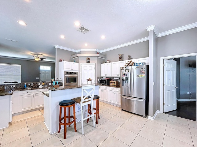 3108 Tom Matthews Rd, Lakeland, FL 33810 - kitchen with appliances with stainless steel finishes, ceiling fan, a center island, light tile patterned floors, and white cabinets
