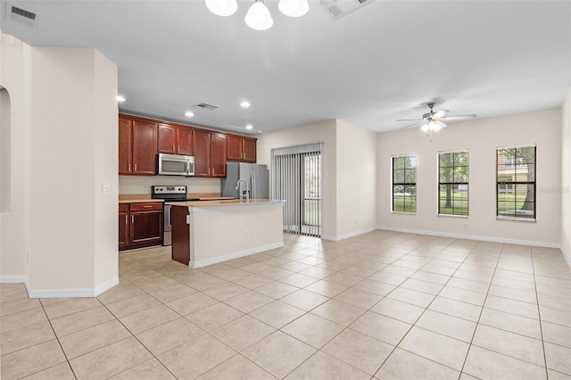 30151 Goodwick Way, Wesley Chapel, FL 33543 - kitchen with stainless steel appliances, open floor plan, light tile patterned floors, and recessed lighting