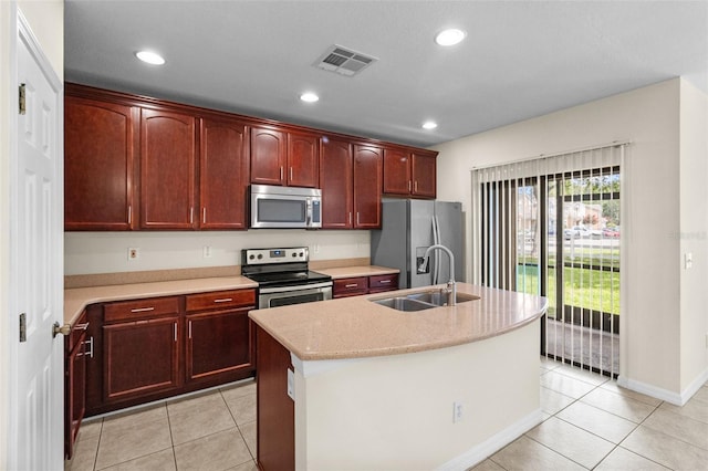 30151 Goodwick Way, Wesley Chapel, FL 33543 - kitchen with appliances with stainless steel finishes, light countertops, reddish brown cabinets, a center island with sink, and recessed lighting