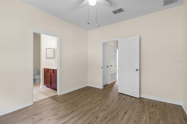 30151 Goodwick Way, Wesley Chapel, FL 33543 - unfurnished bedroom featuring light wood-style floors, ensuite bathroom, and ceiling fan