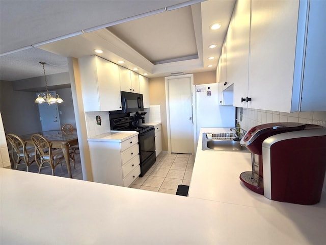 632 Edgewater Dr Unit 633, Dunedin, FL 34698 - kitchen with black appliances, tasteful backsplash, white cabinetry, light countertops, and recessed lighting