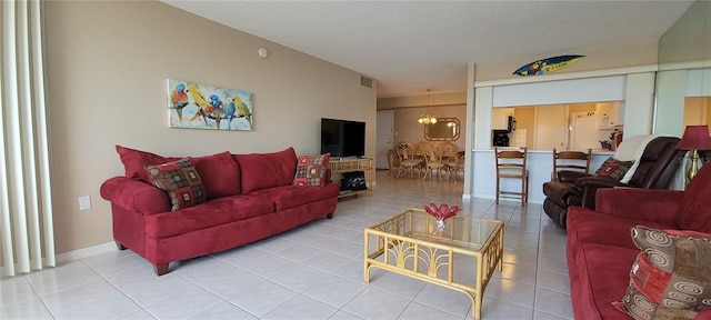 632 Edgewater Dr Unit 633, Dunedin, FL 34698 - living area with light tile patterned floors, a chandelier, and a textured ceiling