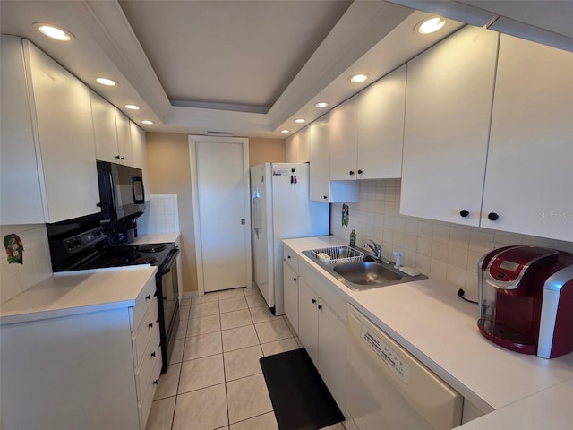 632 Edgewater Dr Unit 633, Dunedin, FL 34698 - kitchen with black appliances, white cabinetry, tasteful backsplash, recessed lighting, and light countertops