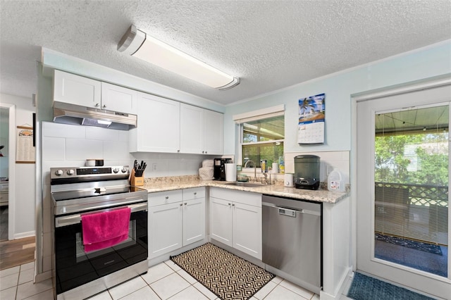 908 Toddsmill Trce, Tarpon Springs, FL 34689 - kitchen featuring stainless steel appliances, under cabinet range hood, white cabinetry, backsplash, and a textured ceiling