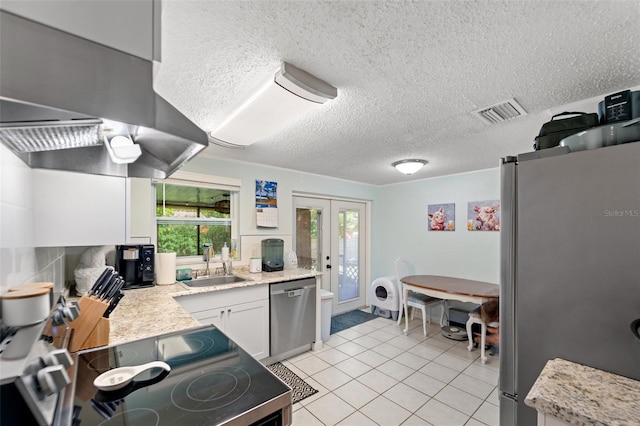 908 Toddsmill Trce, Tarpon Springs, FL 34689 - kitchen featuring appliances with stainless steel finishes, a textured ceiling, light tile patterned floors, wall chimney exhaust hood, and french doors