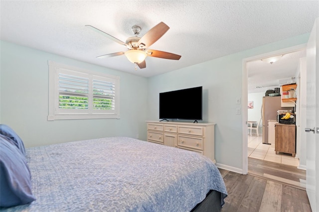908 Toddsmill Trce, Tarpon Springs, FL 34689 - bedroom with wood finished floors, a textured ceiling, a ceiling fan, and freestanding refrigerator