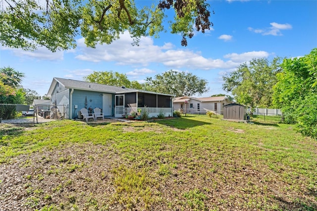908 Toddsmill Trce, Tarpon Springs, FL 34689 - rear view of property featuring a sunroom, a storage unit, and a fenced backyard