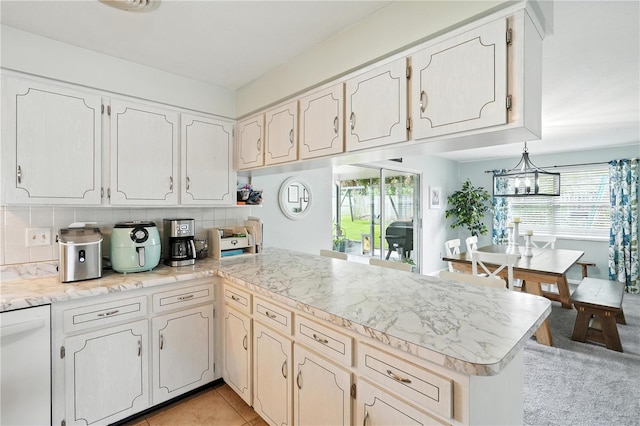 5628 Cypress St, Zephyrhills, FL 33542 - kitchen featuring a peninsula, light countertops, backsplash, white dishwasher, and light tile patterned floors