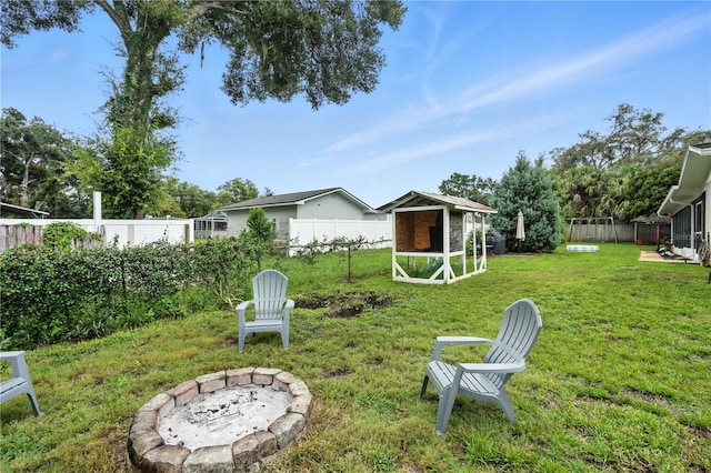 5628 Cypress St, Zephyrhills, FL 33542 - fenced backyard with exterior structure, an outdoor fire pit, and an outbuilding