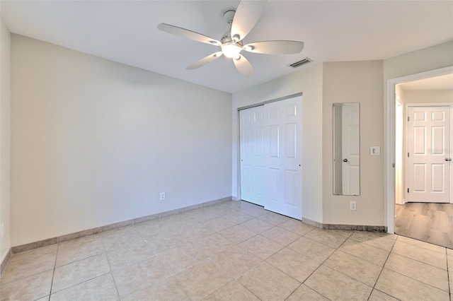 2012 Fall River Ct Unit 107, Sun City Center, FL 33573 - unfurnished bedroom with light tile patterned flooring, a closet, and a ceiling fan