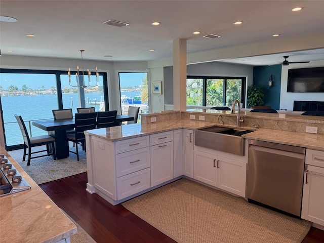 850 59th Ave, Saint Petersburg, FL 33706 - kitchen featuring stainless steel dishwasher, dark wood-style flooring, white cabinetry, open floor plan, and light stone counters