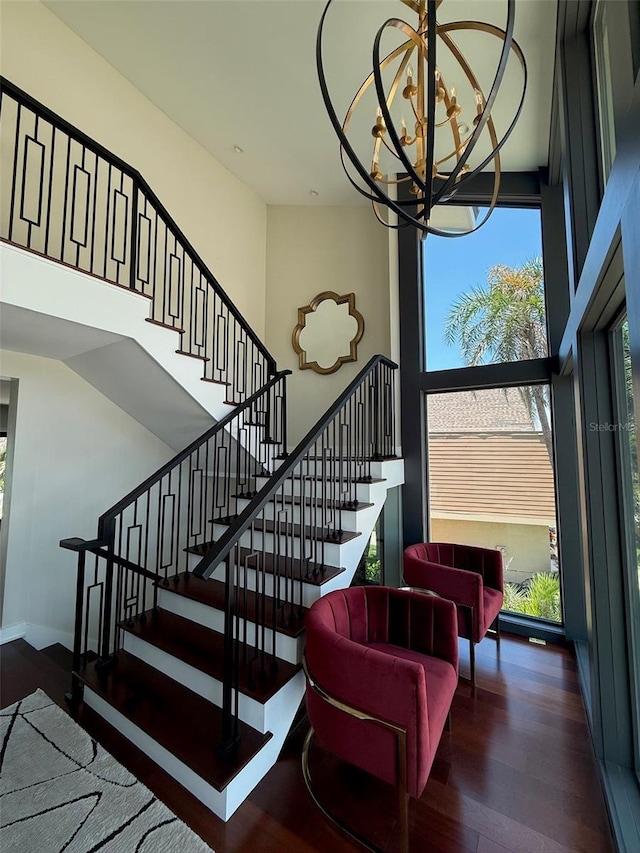 850 59th Ave, Saint Petersburg, FL 33706 - staircase with wood finished floors, a high ceiling, and a chandelier