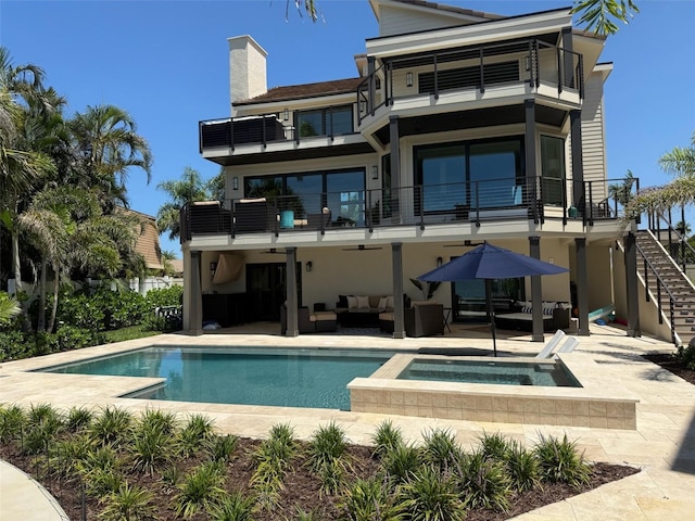 850 59th Ave, Saint Petersburg, FL 33706 - rear view of house featuring a balcony, an outdoor hangout area, a patio area, a chimney, and stairs